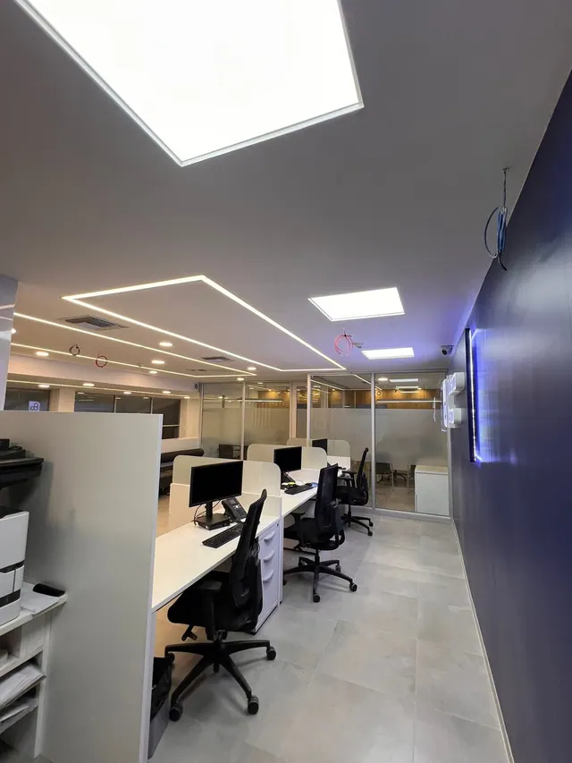 Oficinas con paneles LED y luminarias lineales empotradas